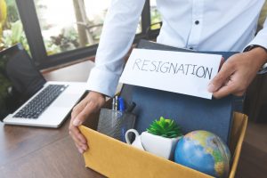 Employee holding resignation letter and packing box